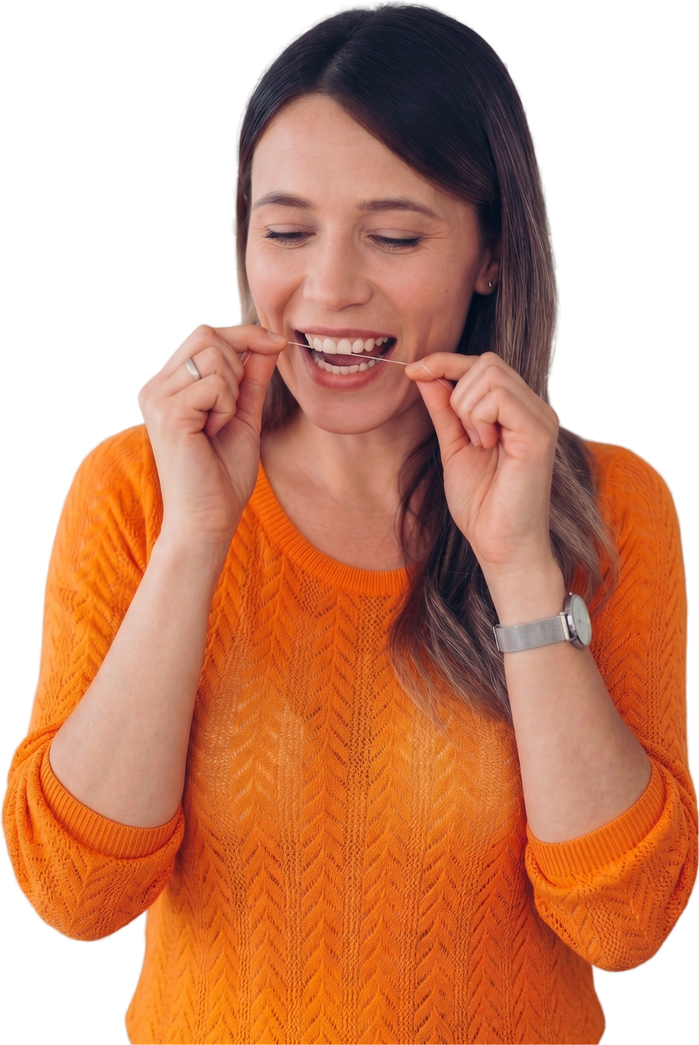 Woman in an orange sweater flossing her teeth