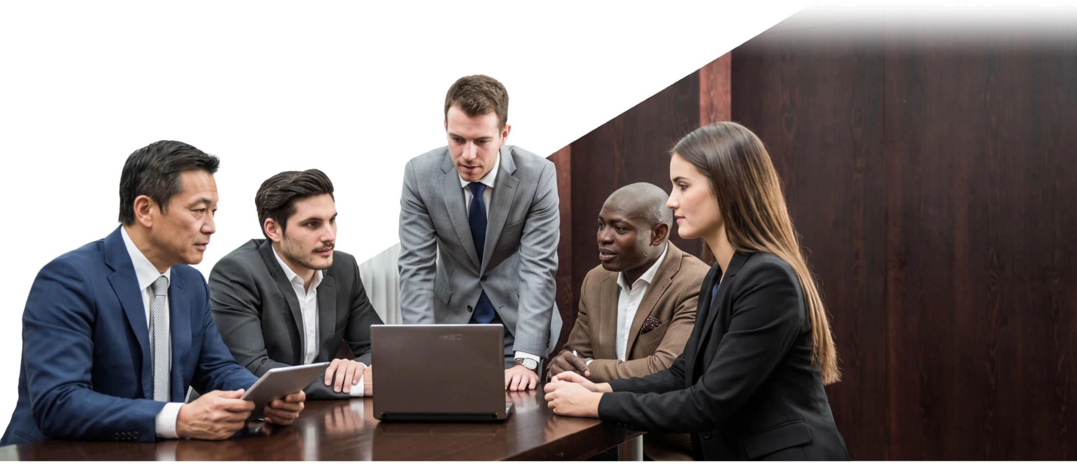 A small team gathered around a laptop in a meeting room