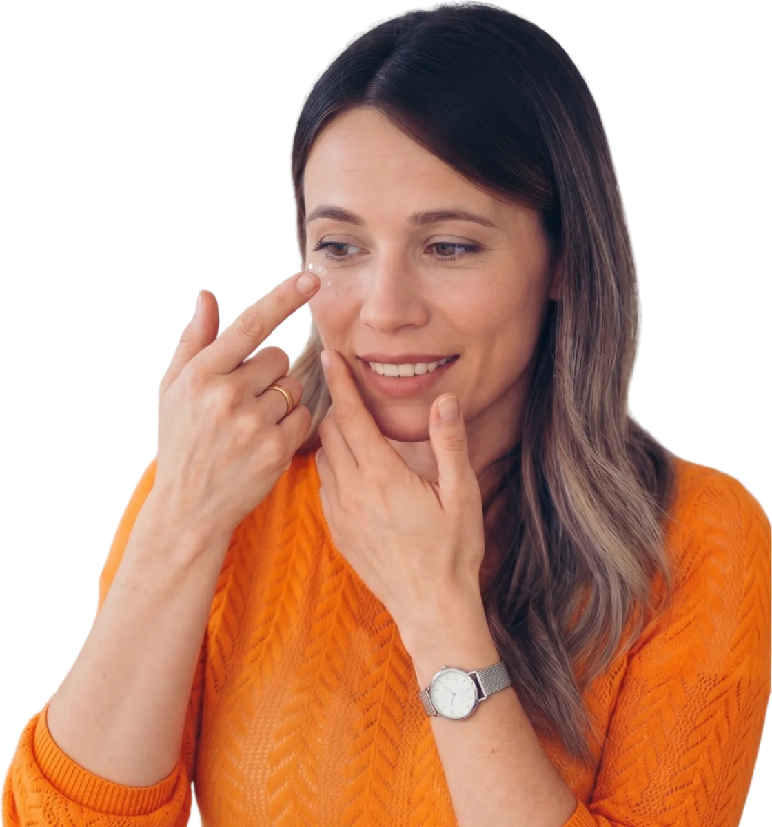 Woman in an orange sweater putting in a contact lens
